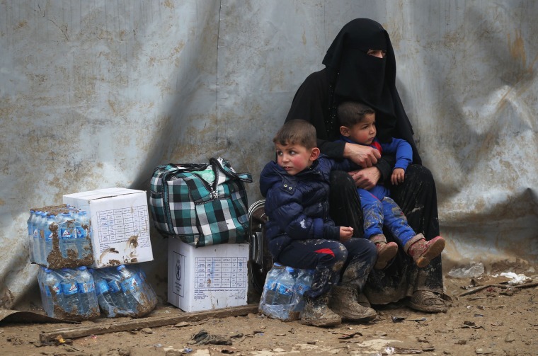 Image: Civilians from Mosul wait after arriving in a camp 