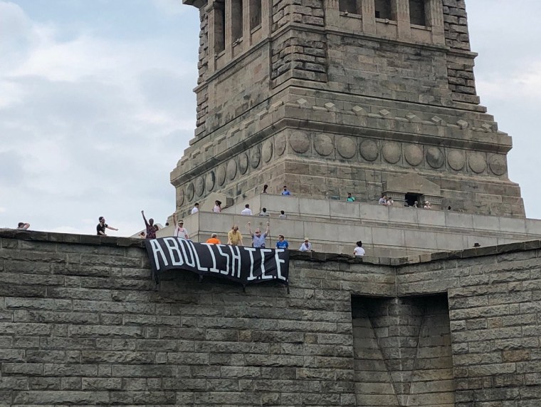 Image: 'Abolish ICE' banner at Statue of Liberty