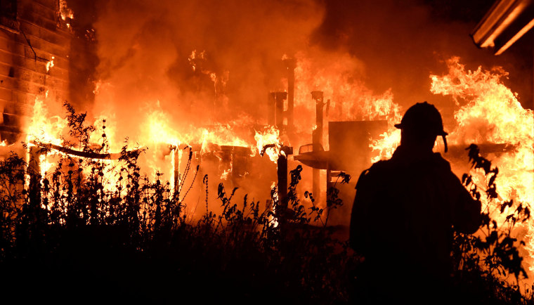 Image: Santa Barbara County firefighters battle flames at a home at the site of a wildfire in Goleta