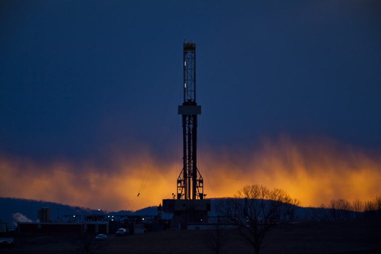 Image:  A hydraulic fracturing drill rig is silhouetted at dusk near Tunkhannock, Pa.
