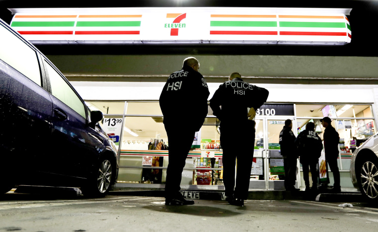 Image: U.S. Immigration and Customs Enforcement agents serve an employment audit notice at a 7-Eleven convenience store