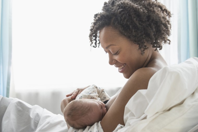 Image: Mixed race mother nursing newborn baby