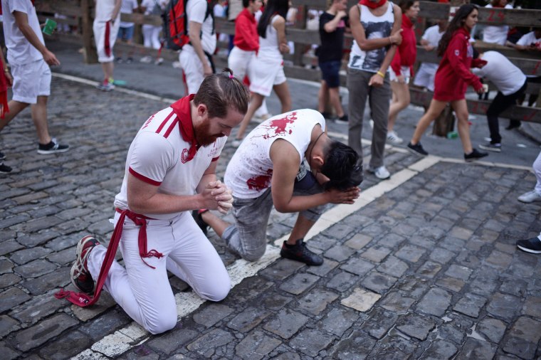 Image: Runners pray before the bull run on the fourth day of the San Fermin festival in Pamplona