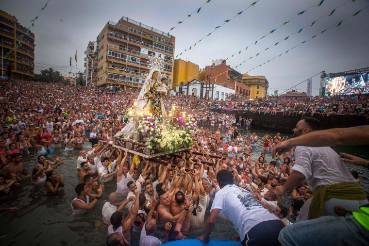 Image: Men unload a statue of the Virgin del Carmen after its journey to Puerto de la Cruz