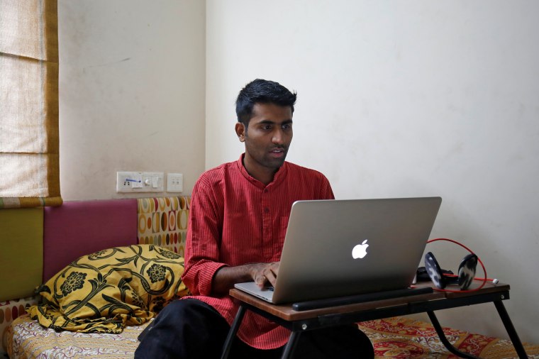 Image: Akhilesh Godi, one of the petitioners challenging India's ban on homosexuality, checks his laptop as he poses inside his house in Bengaluru