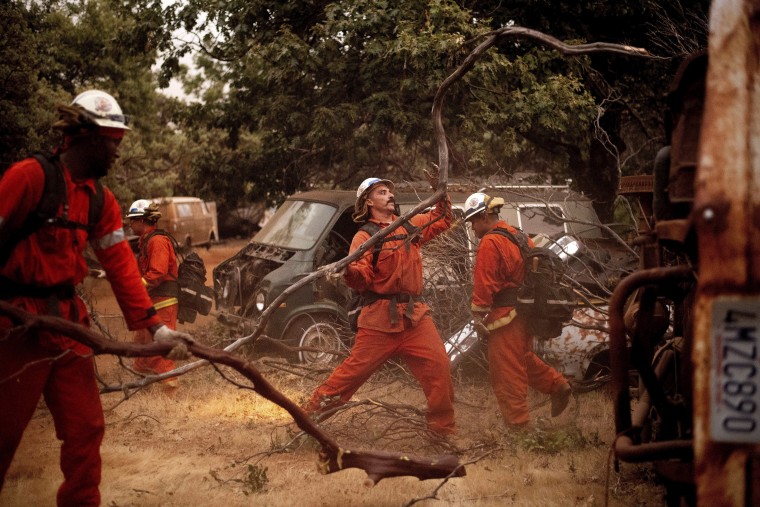 Inmate firefighters clear brush to create a fire break while battling the Ferguson Fire