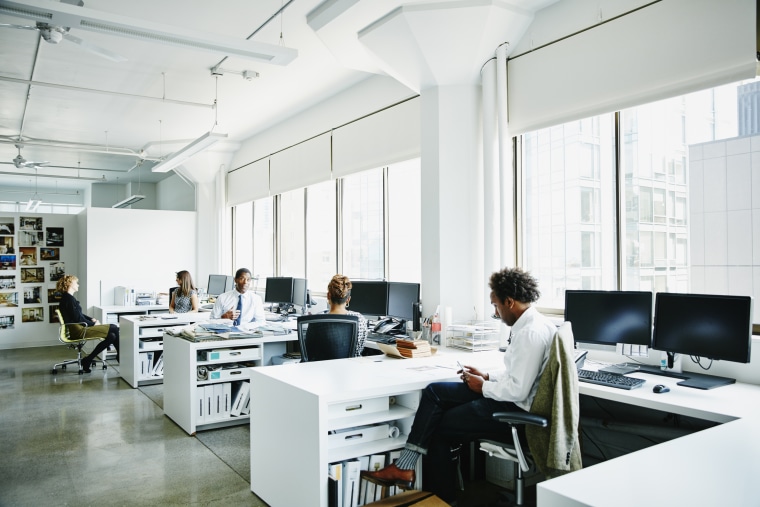 Businesspeople working at workstations in office