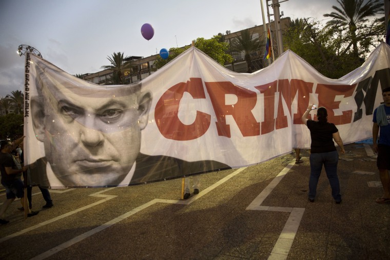 Image: Demonstrators display a banner of Israeli Prime Minister Benjamin Netanyahu during a rally