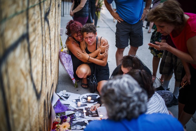 Image: Desirae Shapiro, 19, next to wall kneeling at right, and her mother, Gina Shapiro mourn while visiting a makeshift memorial