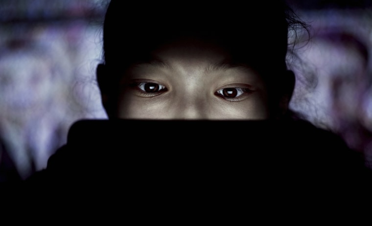 Image: Teen using tablet at night