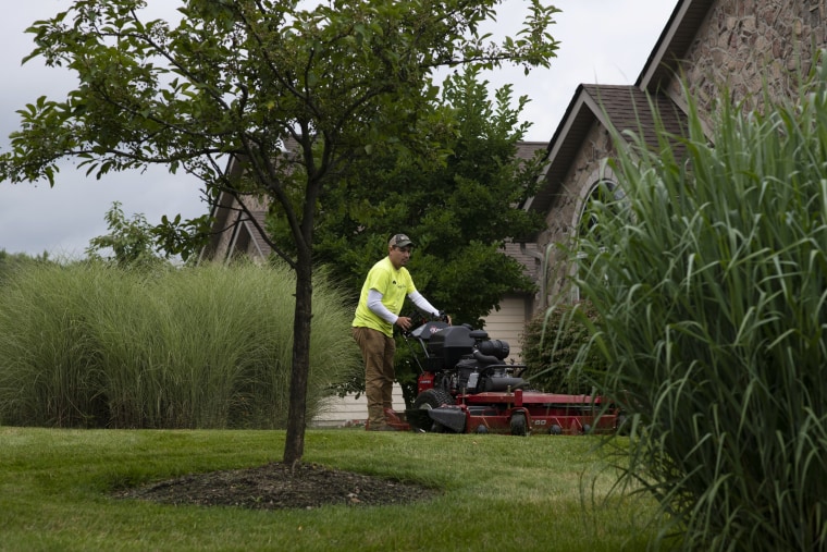 Image: Turfscape Inc. Landscape Technician Alexis Morales mows grass in Aurora, Ohio