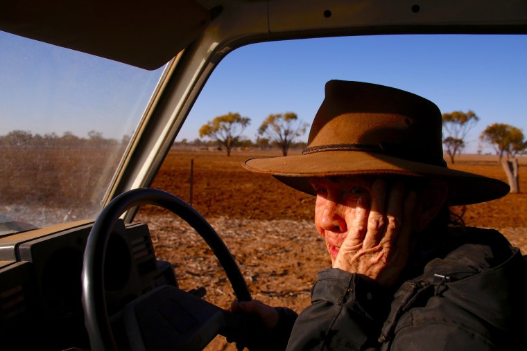 Image: Farmer May McKeown reacts as she drives her truck to feed the remaining cattle on her drought-effected property, located on the outskirts of the north-western New South Wales town of Walgett