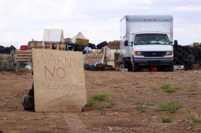 Image: A \"no trespassing\" sign outside the location where people camped near Amalia, New Mexico
