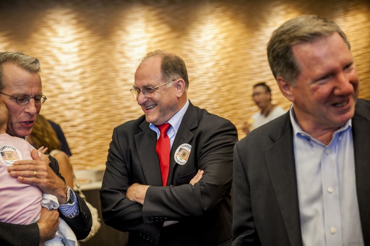 Image: Rep. Mike Capuano, center, talks to supporters during a campaign event