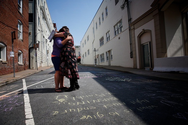 Image: Jenn Franklin, left, and Gretchen Burgess, who were at the deadly clash in Charlottesville last year, embrace