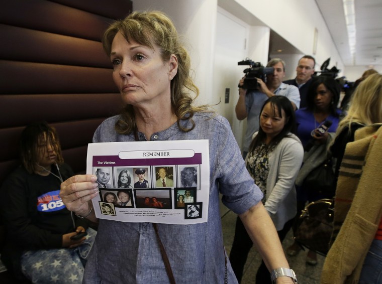 Image: Melanie Barbeau displays photos of murder victims believed to be slain by the Golden State Killer