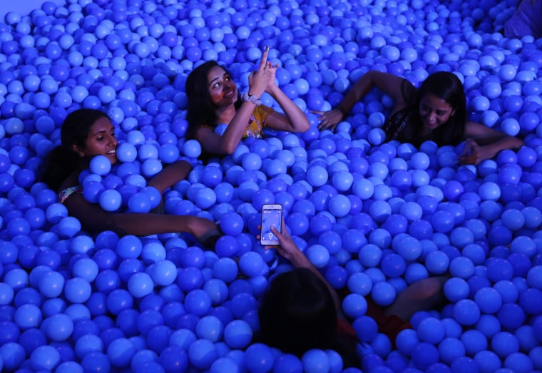 Image: Friends take pictures together in the ball pit at Dream Machine