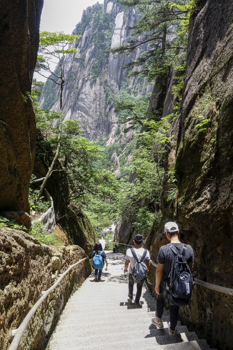 Image: Tourists walk through a narrow pass in Huangshan