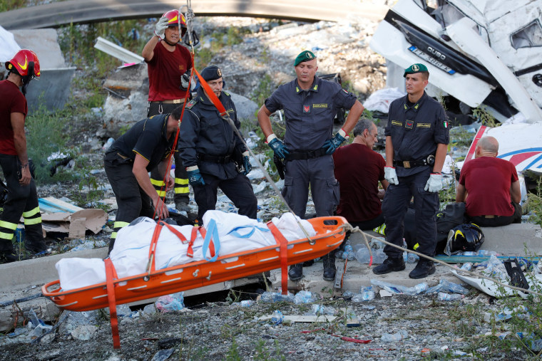 Image: Rescue workers recover a body at the site of the collapsed Morandi Bridge in Genoa