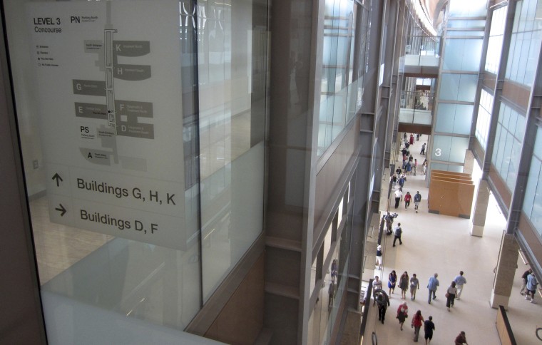 Visitors stroll through a long, glass-walled corridor that connects a dozen buildings at the new Rocky Mountain Regional VA Medical Center in Aurora, Colorado, after a ribbon-cutting ceremony at the hospital on July 21, 2018.