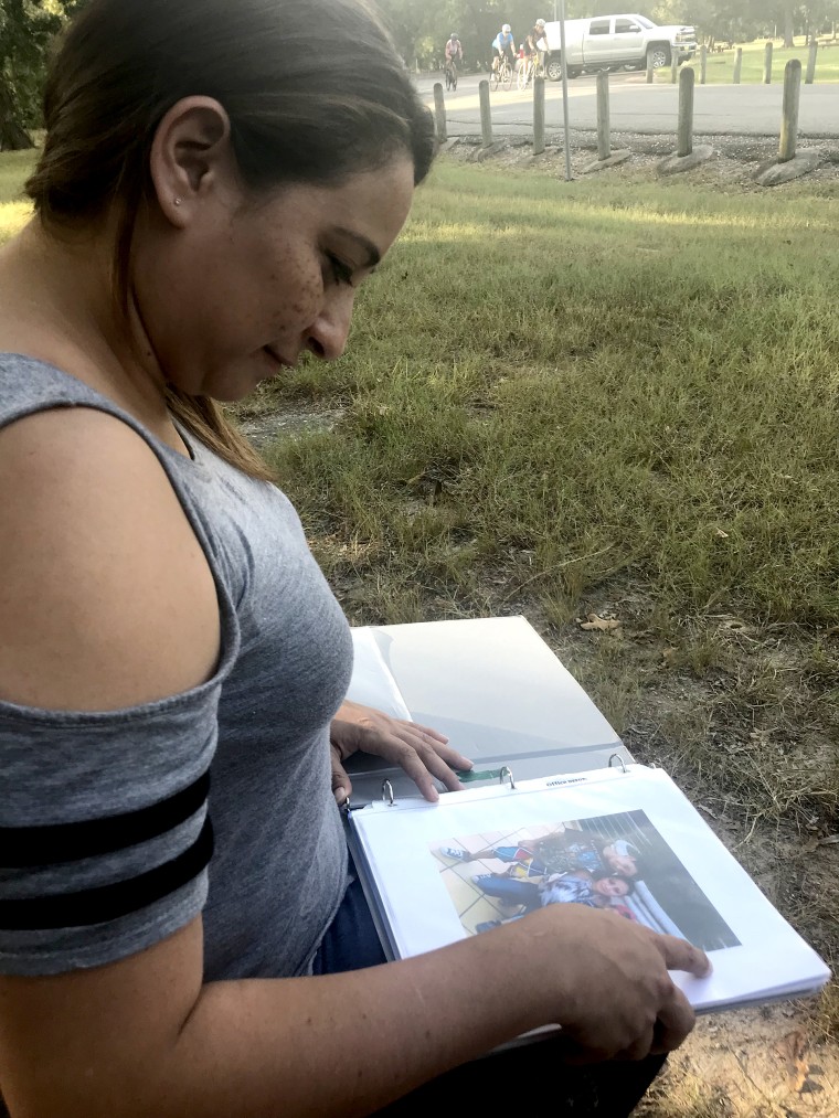 Raquel, who has been separated from her sons since the end of June, looks at photos of them.