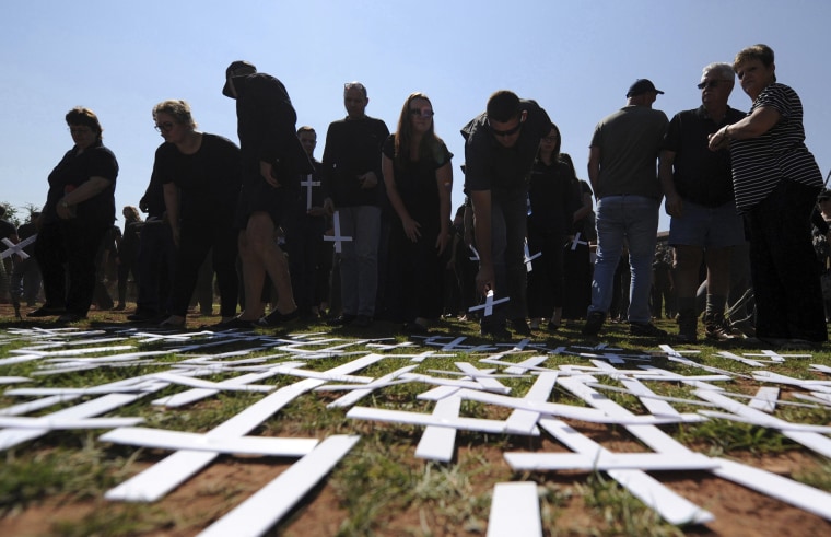 Image: People place white crosses, symbolically representing farmers killed in the country, at a ceremony at the Vorrtrekker Monument in Pretoria