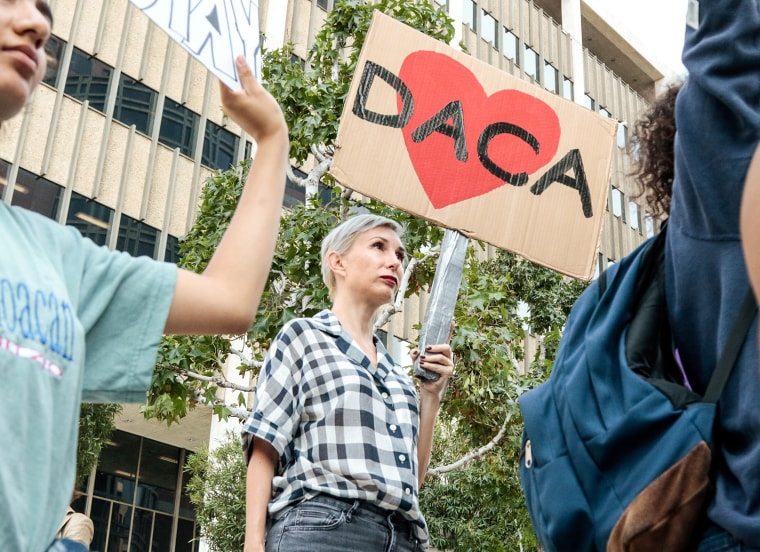 Image: Allison Agsten of Los Angeles stands with supporters of the Deferred Action for Childhood Arrivals (DACA) program during a rally outside the Edward R. Roybal Federal Building in Los Angeles, California