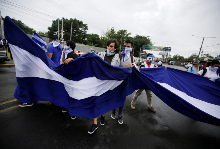 Image: Students hold a national flag while marching during a protest against the government, in Managua