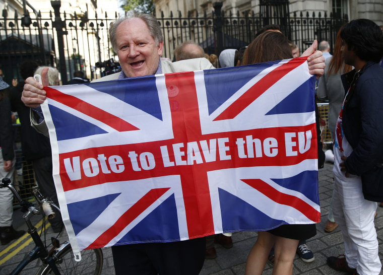 Image: A vote leave supporter holds a Union flag, following the result of the EU referendum, outside Downing Street in London