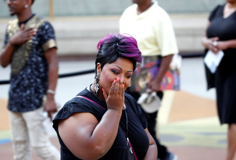 Image: A woman becomes emotional as people file past the body of the late singer Aretha Franklin