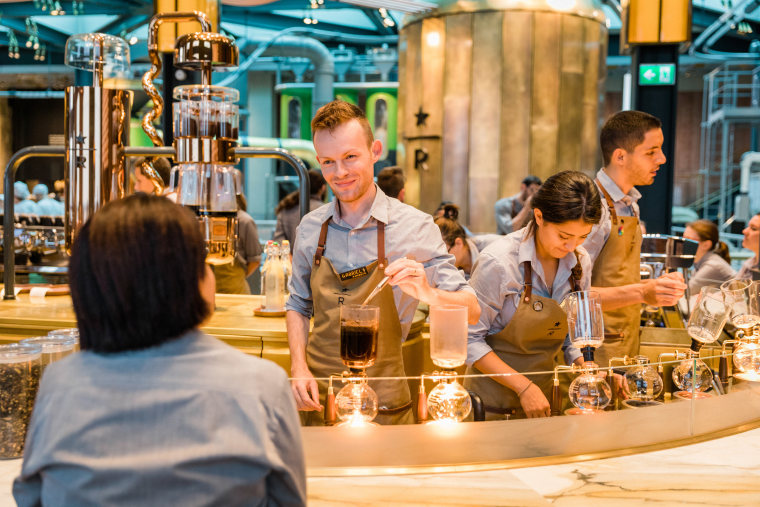 Starbucks barista Gabriel Sebastian Denes works at the siphon brewing station at the Starbucks Reserve Roastery in Milan, Italy on Sunday, August 02, 2018. (Joshua Trujillo, Starbucks)