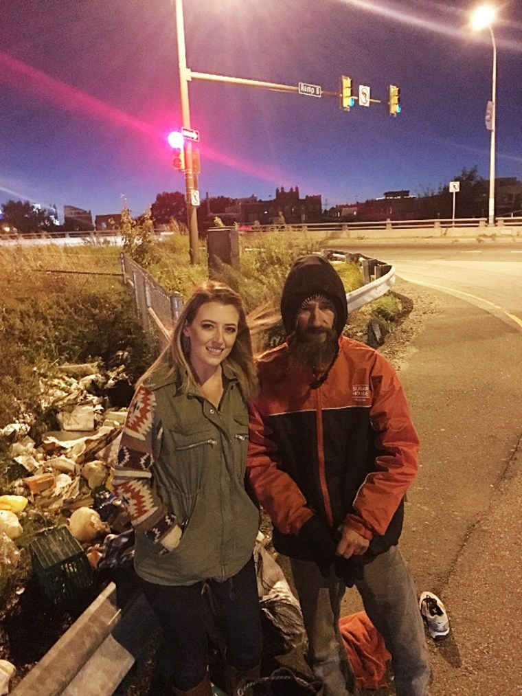 Image: Kate McClure stands with Johnny, the homeless man that gave her his last 20 dollars to fill her car with gas when it broke down on the side of I-95. Kate is trying to raise money for Johnny so he can get back on his feet.
