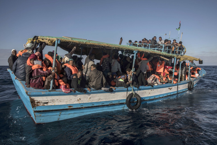 Image: Migrants wait to be rescued off Libya's coast