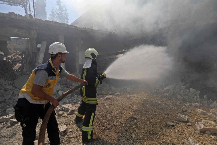 Image: Firefighters battle a blaze after an airstrike in Jadraya, Syria