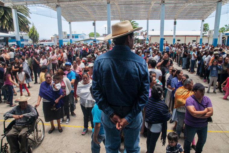 Image: Townspeople form behind Salvador Campanur during the community elections on May 27, 2017