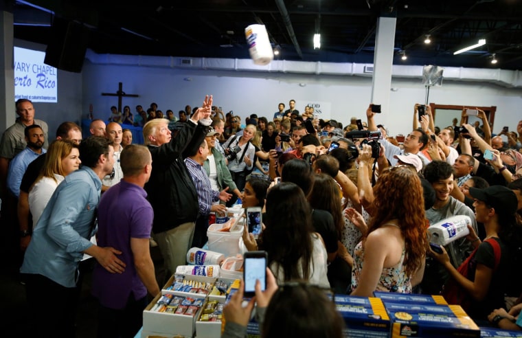 Image: President Trump throws paper towels to residents gathered in a chapel while visiting areas damaged by Hurricane Maria in San Juan, Puerto Rico