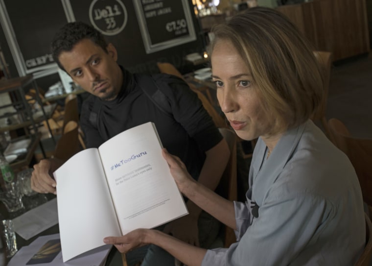 Image: Ricardo Mendes, left, and Oane Bijlsma, two of four alleged victims of sexual, physical and psychological abuse show the report titled they presented the Dalai Lama.