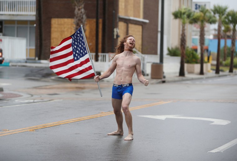 Image: Lane Pittman of Jacksonville, Florida, stands in the wind and rain along Ocean Boulevard during Hurricane Florence in Myrtle Beach