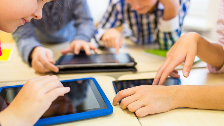 Image: close up of school kids playing with tablet pc