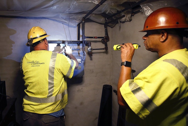 Image: Columbia Gas employee Brian Jones shines a flashlight so his partner, using a wrench, can shut off the gas in a home on Sept. 14, 2018, in Andover, Massachusetts.