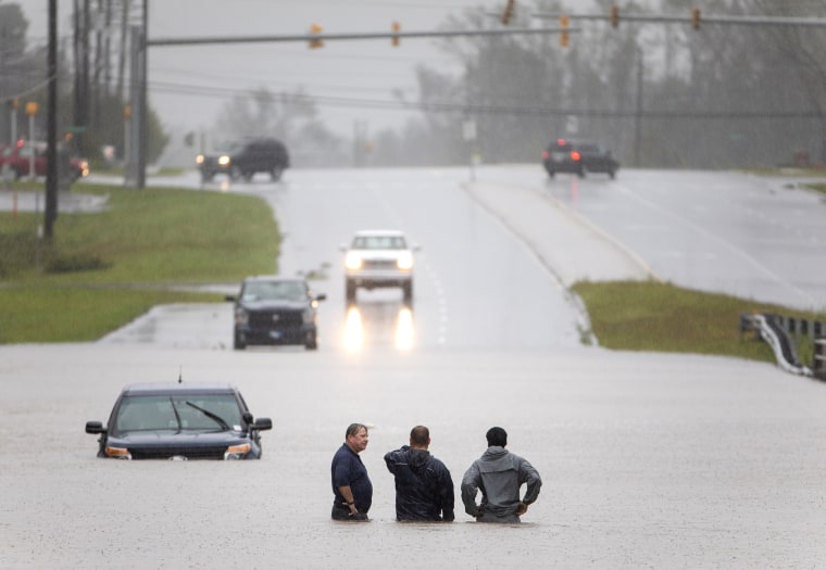 Image: Bystanders help a stranded motorist after floodwaters from Hurricane Florence