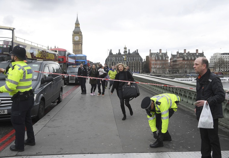 Image: A woman ducks under a police tape after an incident on Westminster Bridge in London