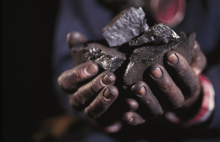 Image: Hands holding lumps of coal