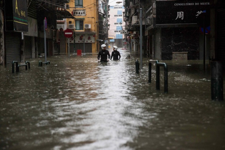 Image: Rescue workers make their way through flood waters after Typhoon Mangkhut hit Macau on Sunday.