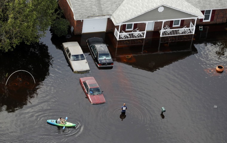 Image: A man paddles a kayak in a flooded neighborhood in the aftermath of Hurricane Florence, in Fayetteville