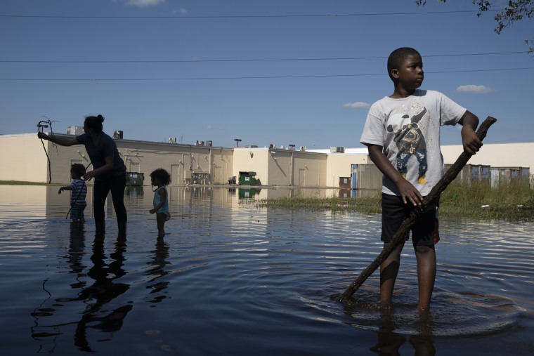 Image: Xavier Hamilton plays in floodwater in front of their home in Lumberton, North Carolina