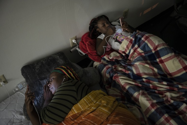 Image: Shekila Dupris and her daughter Nia rest in a church shelter after being forced out of her home due to flooding in Lumberton