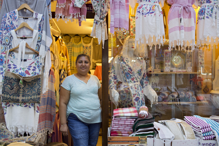 Image: Pembe Cavdar waits for customers at her Bursa clothing store