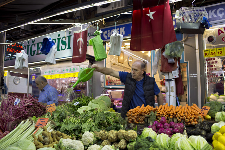 Image: A trader sprinkles vegetables with water in Bursa, Turkey.