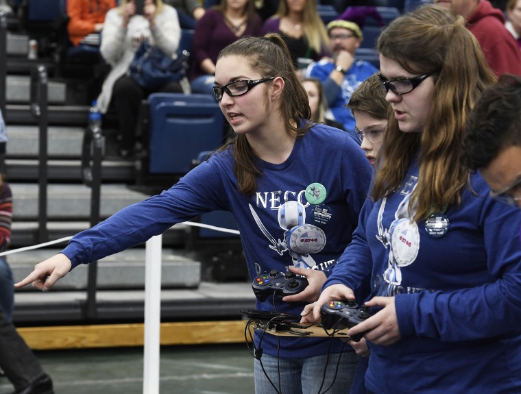 Image: Students representing the Neco Robo Knights help each other out during a round of the FIRST Tech Challenge robotics competition